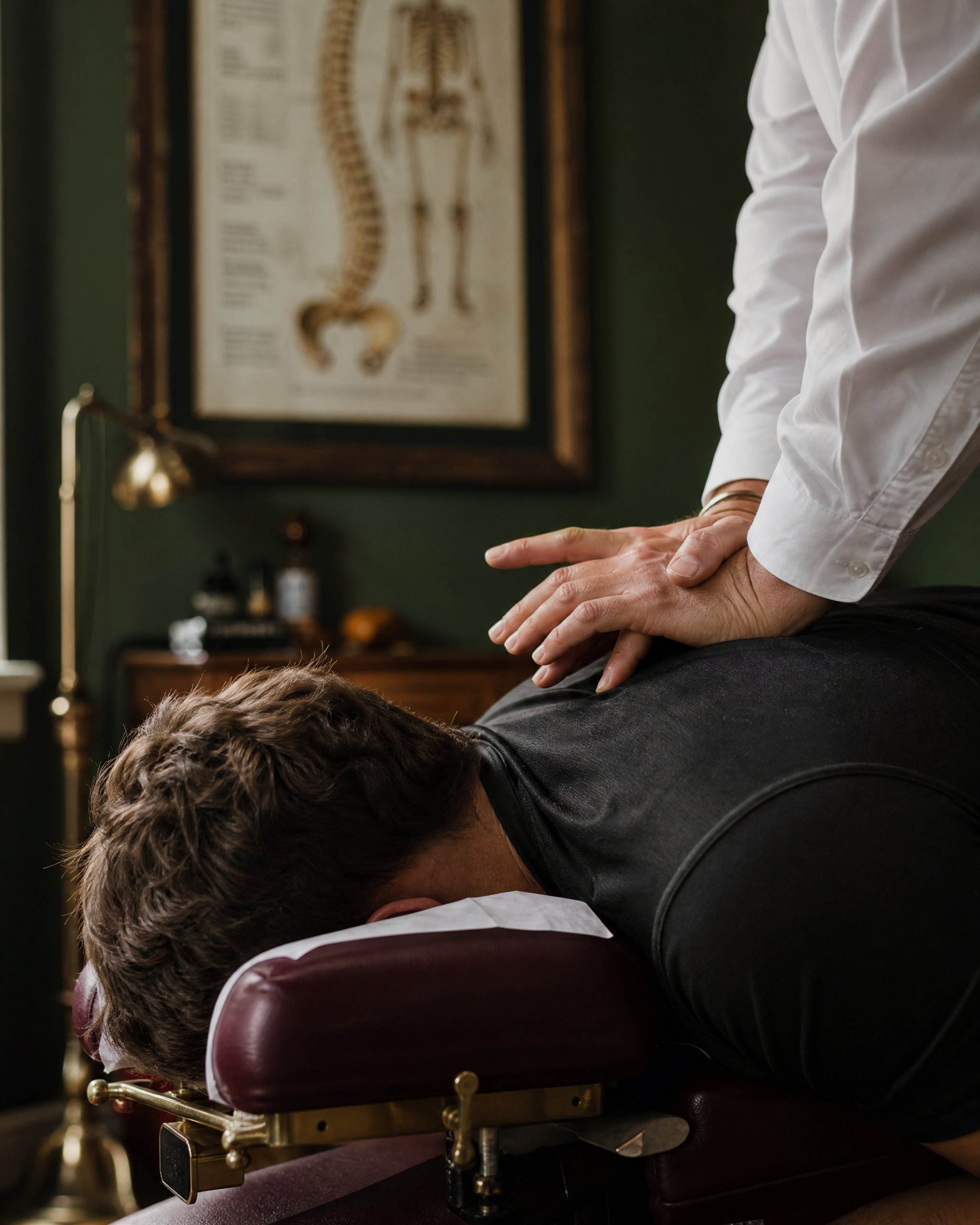 Chiropractic adjustment in a wood-paneled treatment room